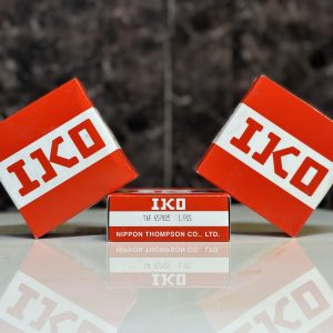 جعبه‌های قرمز و سفید بلبرینگ IKO روی سطحی براق, محصول Nippon Thompson Co., Ltd.